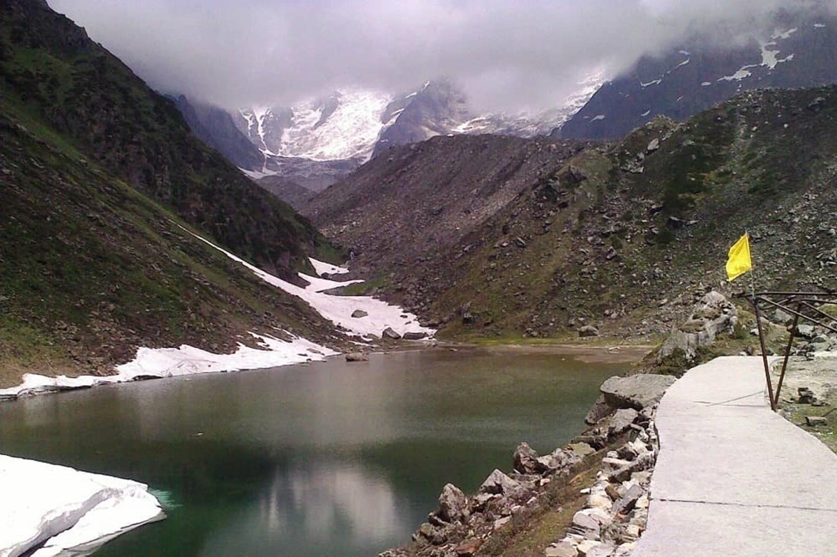 View of Chorabari lake with greenish water and snow capped mountains around