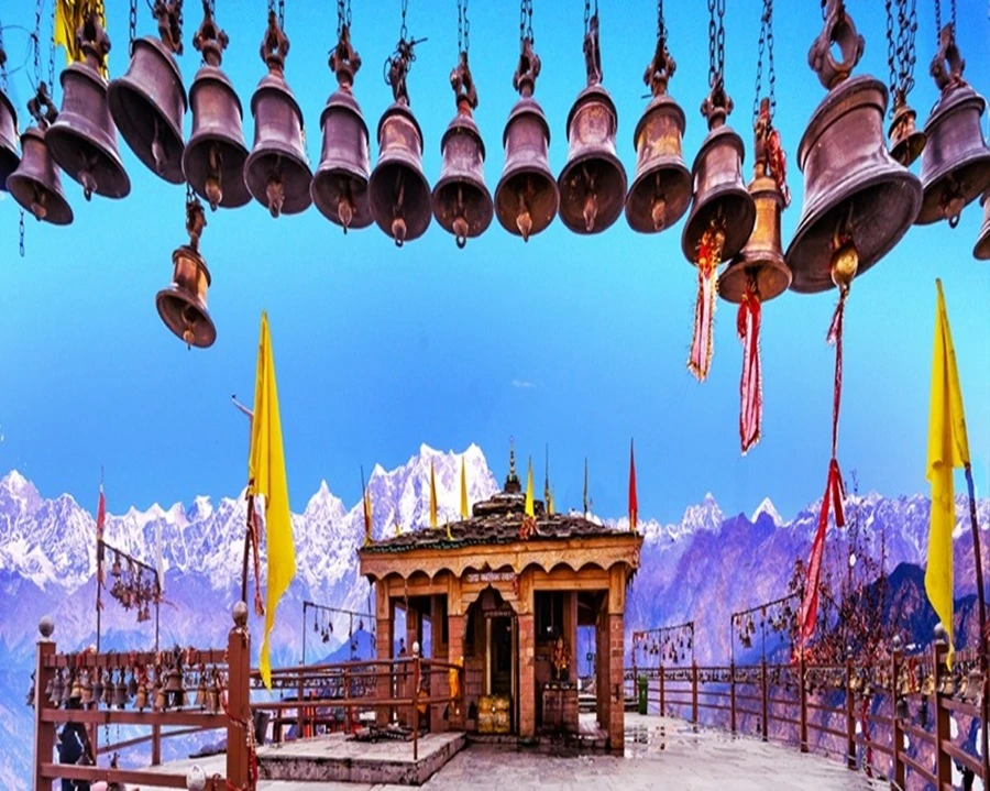 Bells hanging in front of Kartik Swami temple of Uttarakhand with snow capped mountains in the background
