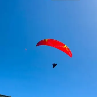 Red tandem paraglider in the sky above Bir