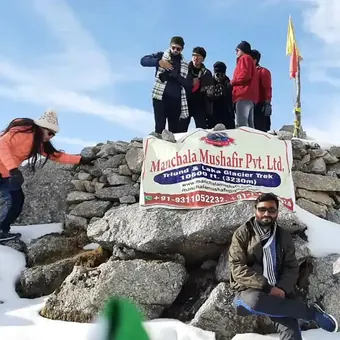 Trekkers on the stone cairn at Laka Glacier in the snow