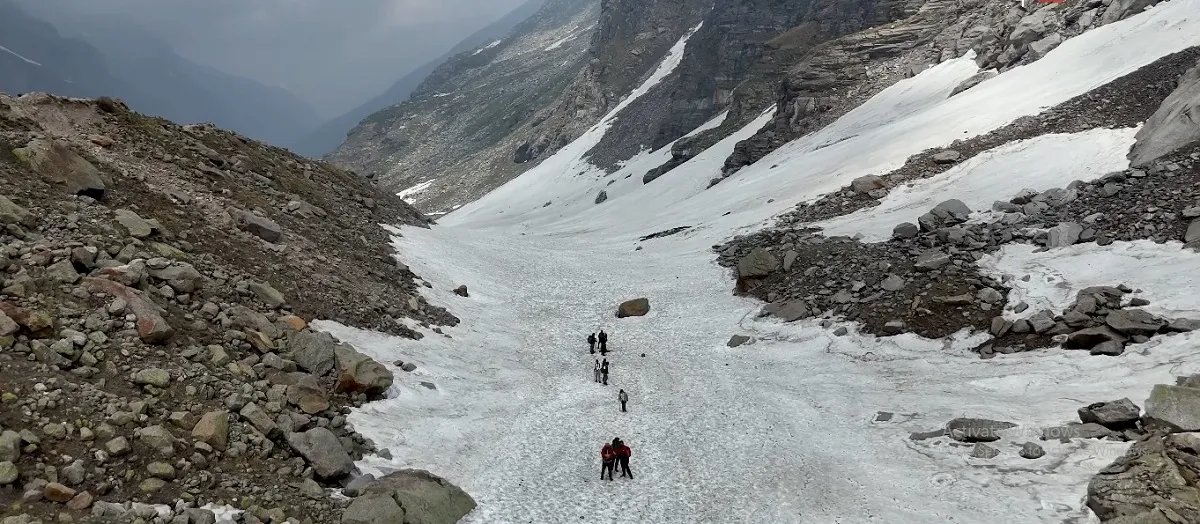 trekkers crossing a snowfield on the Hampta Pass trek