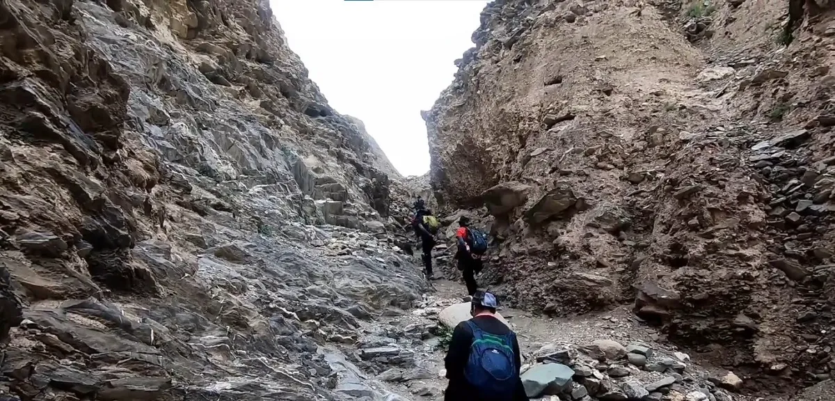 trekkers walking through a narrow rocky gorge on the Markha Valley trek