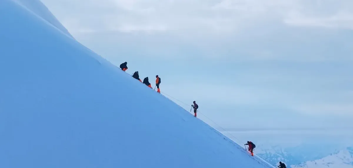 Fixed-rope climb on Friendship Peak summit day Climbers clipped to a fixed rope on a steep snow slope during the Friendship Peak summit climb