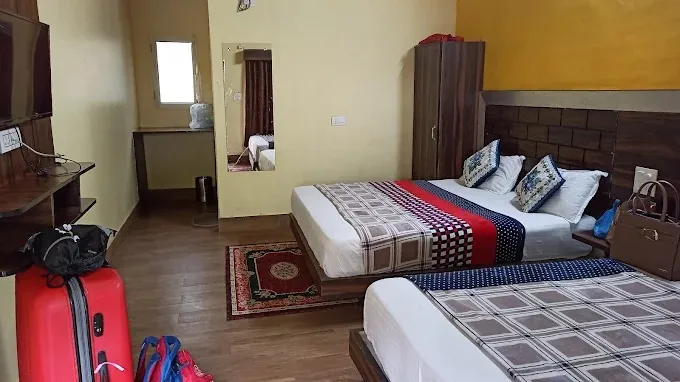 Room at Nakshatra Resort with two double beds for quad sharing, a wardrobe and a mirror
