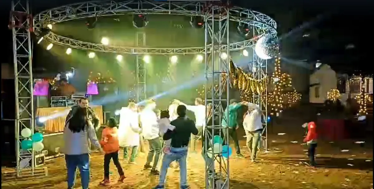 Guests dancing under the lights of the DJ stage on New Year's Eve at the camp