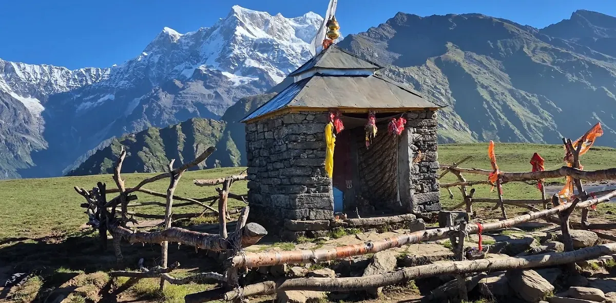 Small Budha Madhyamaheshwar shrine on a meadow with the snow-covered Chaukhamba range behind