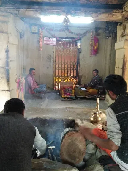 Priests seated at the Akhand Dhuni inside Triyuginarayan Temple